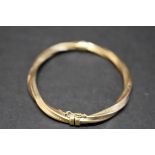 A 9ct twisted gold hinged bangle, 7g.