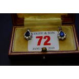 A pair of treated sapphire and cubic zirconia pendant earrings.