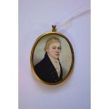 English School early 19th century, bust length portrait miniature of a gentleman in a navy blue