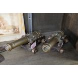 A pair of antique brass model cannons, on oak carriages, the cannons 19.5cm long.