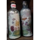 A pair of antique glass bottles, each containing fruit and flower specimens. preserved in salt,