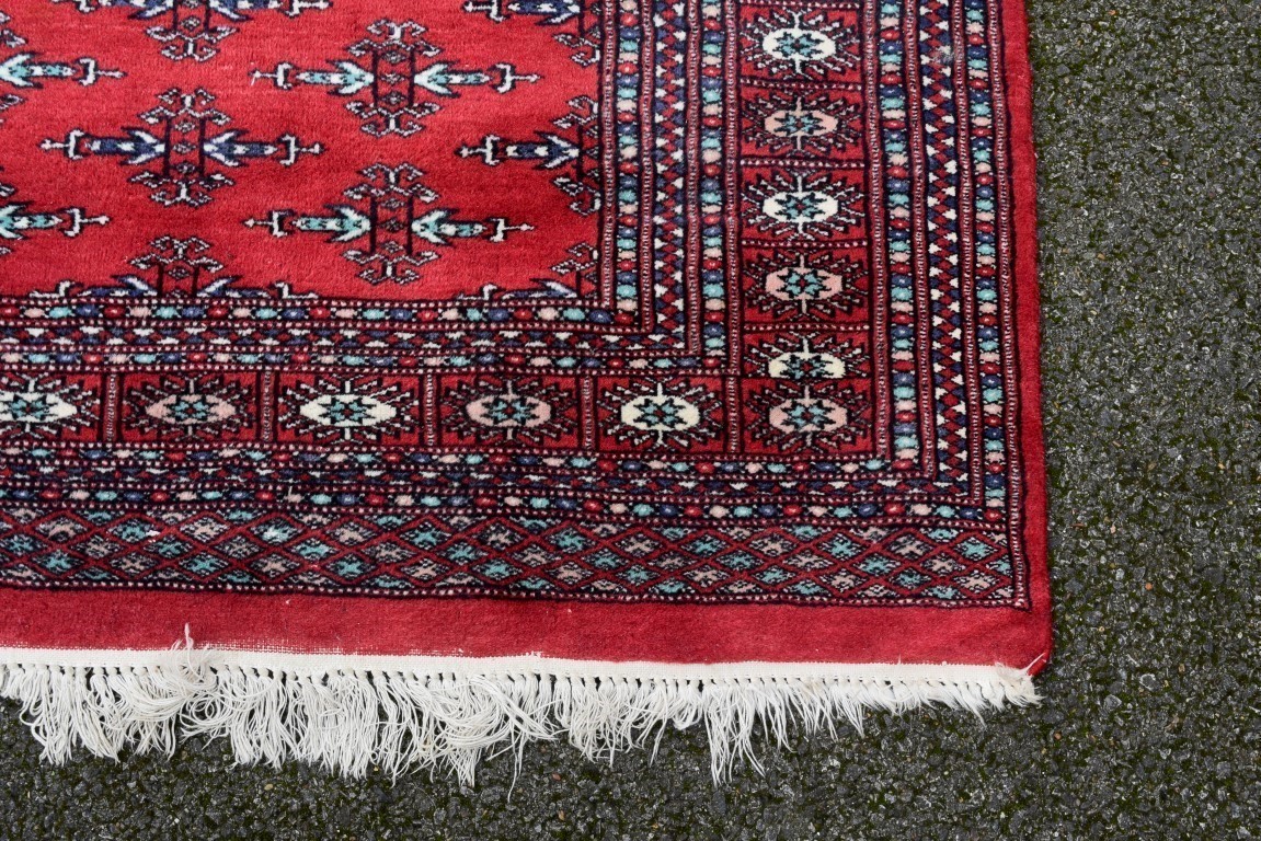 A Pakistani rug, having allover floral and geometric design on a red ground; together with a similar - Image 2 of 3