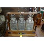 An late 19th/early 20th century oak and electroplate mounted three bottle tantalus, 35.5cm wide, (