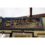 A South Seas carved and polychrome painted wood panel, 40 x 96.5cm.