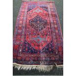 A Persian carpet, having large central medallion with allover geometric design on a red ground, a.f.