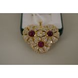 An unmarked yellow metal diamond and cabochon ruby pendant, 4cm diameter.