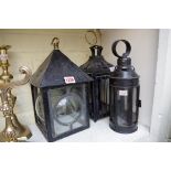 Three old black painted lanterns, largest 31cm high.