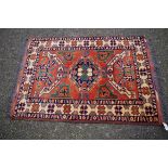 A Persian rug, having floral and geometric design on a orange ground; together with two similar