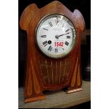 An Art Nouveau mahogany and inlaid mantel clock, with enamel dial, 26cm high, with pendulum.