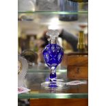 A blue overlaid clear glass scent bottle and stopper, with silver collar, 12cm high.