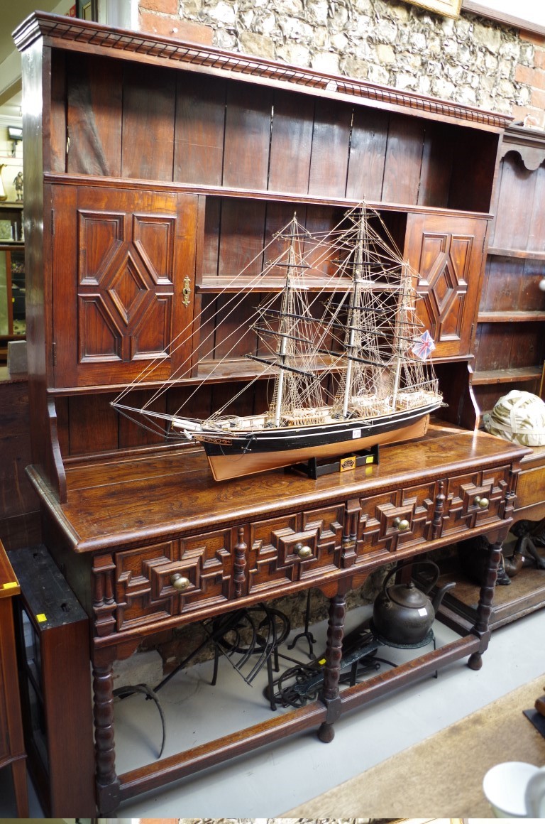 An 18th century oak dresser base, with geometrically moulded frieze drawers above reel turned legs