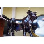 A treacle glaze model of a bull, 31cm high, (a.f.)