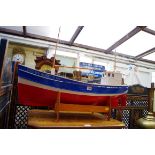 A painted wood model of a fishing trawler, the hull 85cm long, on plywood stand.