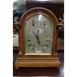 An early 20th century mahogany mantel clock, with silvered arched dial, 36.5cm high, with pendulum.