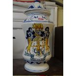 A tin glazed drug jug and cover, painted with a coat of arms, the base inscribed 'Academica London',