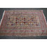A Persian rug, having repeated medallions to central field on a cream ground with floral and