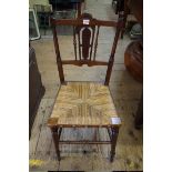 A pair of Edwardian mahogany and rush seated salon chairs.