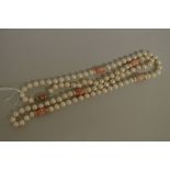 A cultured pearl single strand necklace, the pearls interspersed with five carved coral beads and