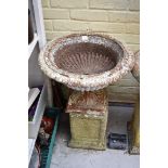 A Victorian cast iron campana urn, 53cm diameter, on associated composition stone pedestal.