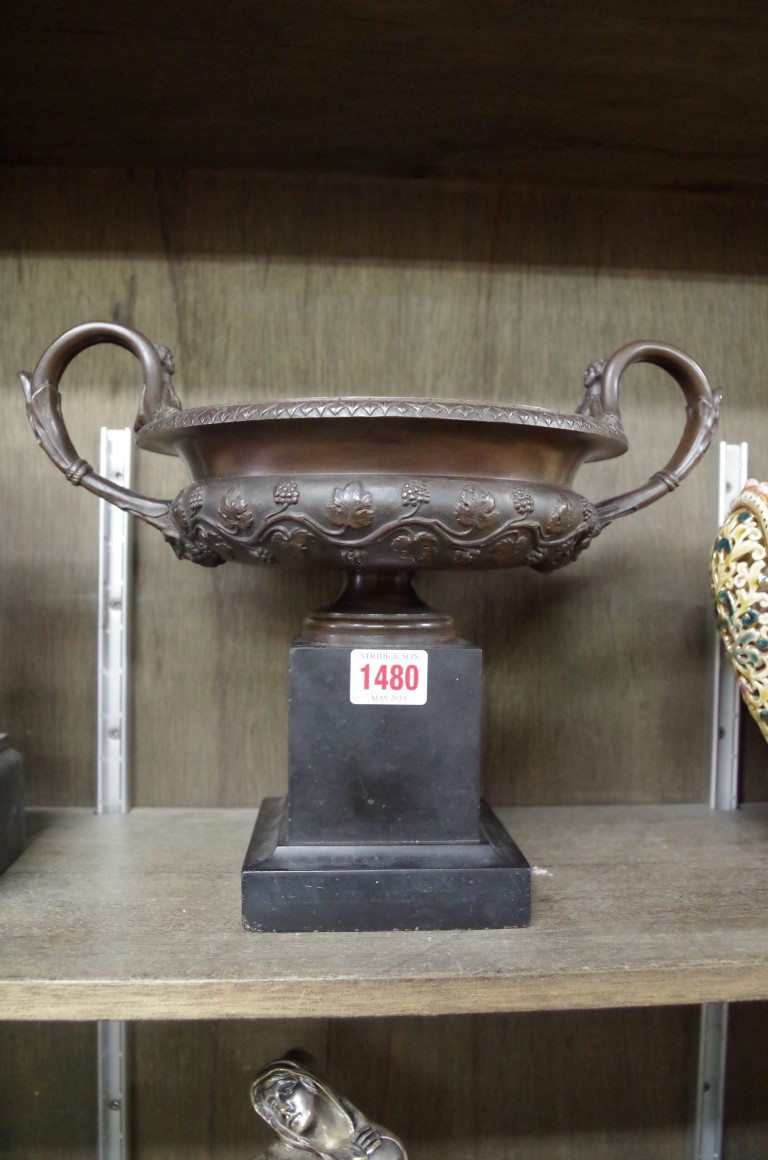 A 19th century bronze twin handled campana urn, on slate base, 32cm wide.