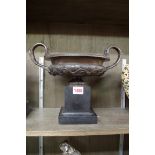 A 19th century bronze twin handled campana urn, on slate base, 32cm wide.