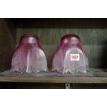 A pair of cranberry glass light shades, 14cm high.