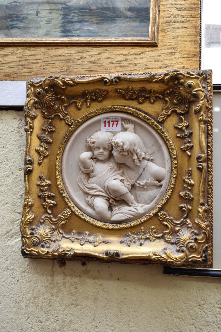 A reconstituted relief moulded marble plaque of cherubs,Â 17cm diameter.