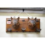 A Black Forest novelty carved wood fox head pipe stand,Â wall mounted, 31.5cm wide.