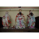 Three Chinese famille rose figures, the Emperor, 38.5cm high.