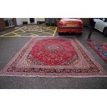 A Persian style carpet,Â having central floral medallion with allover floral design on a red ground,