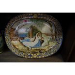 An Italian Maiolica oval charger,Â probably 18th century, painted with two lovers in a landscape,