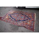 A Tabriz rug,Â having central floral medallion on a red ground with floral decoration to border, 142