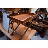 A walnut butlers tray, 75cm wide, on folding X frame stand.