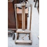 An antique pine artist's easel, on castors.