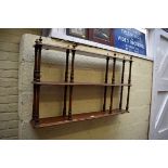 A set of walnut three tier hanging wall shelves, 105cm wide.