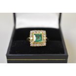 A square cut emerald and diamond gold ring, stamped 750.