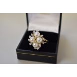 A floral cluster gold ring set four pearl and fourteen diamonds,Â hallmarked 375, 4.9g all in.
