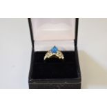 A marquis cut London blue topaz gold ring,Â having diamond set step shoulders, stamped 14k.