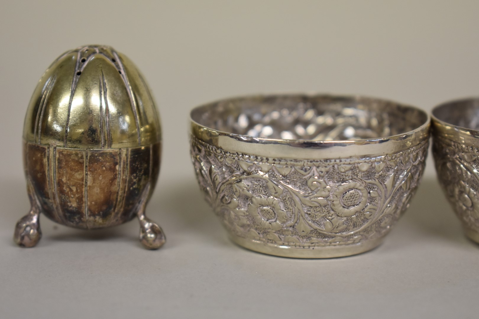 Three Arabic floral chased white metal salts; together with a pair of metal pepperettes. - Image 2 of 4