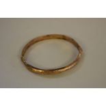A gold hinged bangle, stamped 375, 6.5g.