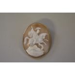 A large oval carved shell cameo brooch depicting St George and the Dragon, having 9ct gold plaque to