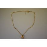 A box link gold chain with a gold gypsy caravan charm attached,Â both hallmarked 375, 8g.