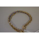 A tanzanite set gold bracelet,Â the clasp stamped 10k, 21cm, 10.6g all in.