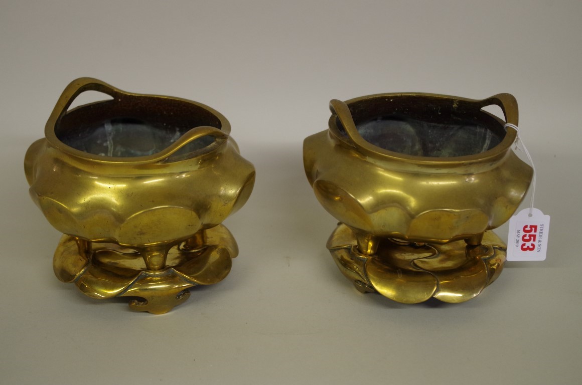 A pair of Chinese brass twin handled tripod censers and covers, 17cm wide.