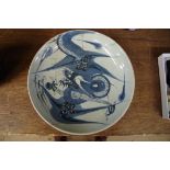 A Chinese blue and white plate, 17th century, painted with a dragon, 28cm diameter, (cracks and