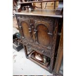 A reproduction carved oak small side cabinet, 68cm wide.