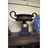 A 19th century bronze twin handled campana urn, on slate base, 32cm wide.