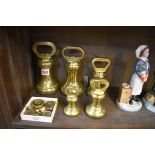 A matched graduated part set of five brass bell weights; together with a further collection of