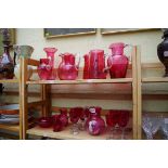 A collection of cranberry glass. (two shelves)