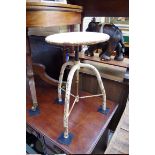 An industrial white painted steel adjustable tripod stool.